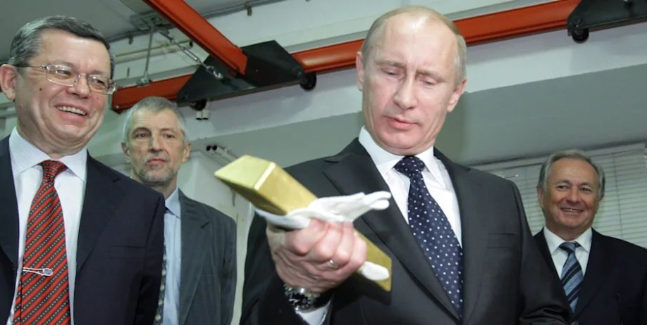 Putin looks at a gold brick